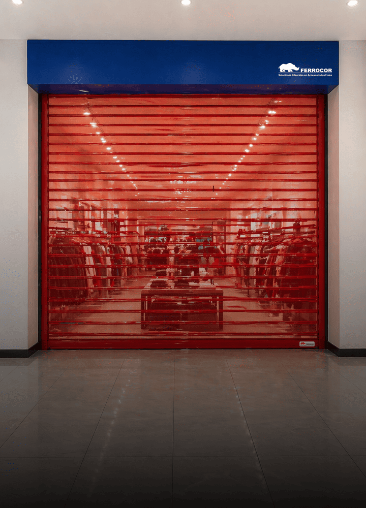 Puerta enrollable comercial premium roja con vitrina visible y cubre motor azul en tienda retail